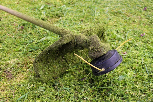 La tondeuse est allongée sur l'herbe tondue