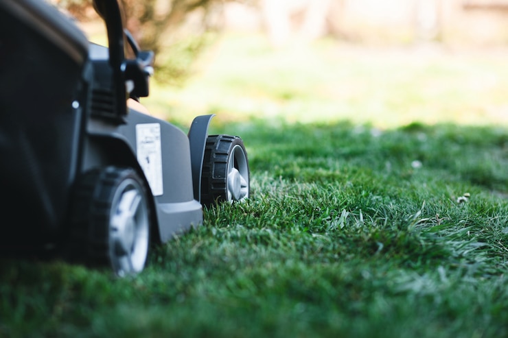 Photo tondeuse à gazon électrique sur une pelouse au jardin