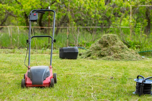 Tondeuse à gazon électrique sur la pelouse sur fond d'herbe tondue