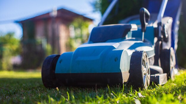 Tondeuse à gazon sur l'herbe verte dans le jardin ou l'arrière-cour moderne Machine pour couper les pelouses Outils et équipements d'entretien du jardinage