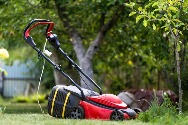 Tondeuse à gazon sur une pelouse dans le jardin jardinage Terrain paysager à l'arrière-cour Équipement spécial pour terrain paysager Concept de jardinage Gros plan