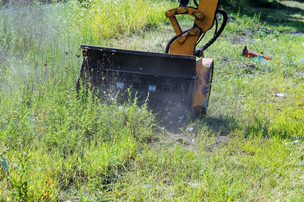 Tondeuse à gazon avec tracteur à roues avec équipement de tondeuse monté détachable externe roulant sur le bord de la route d'une autoroute de banlieue