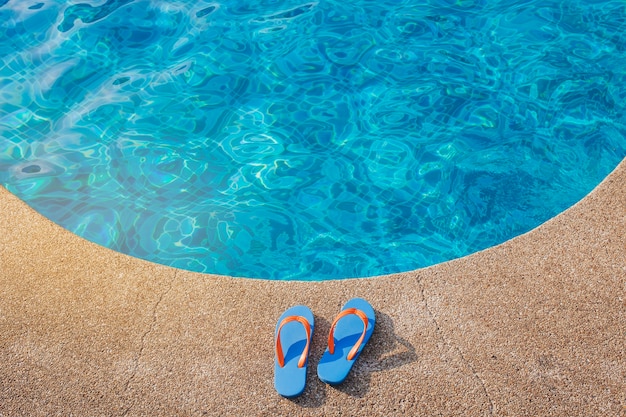 Tongs bleus près de la piscine