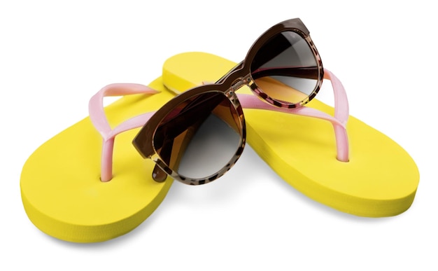 Tongs jaunes et lunettes de soleil sur blanc