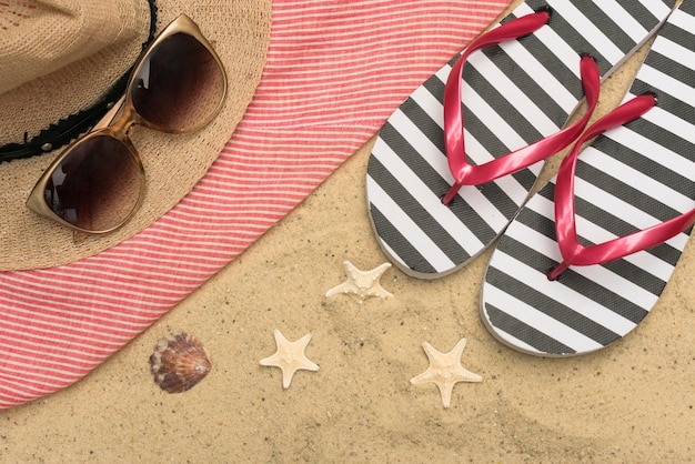 Tongs et lunettes de soleil dans le sable Concept de vacances d'été