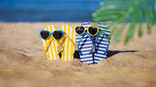 Photo tongs et lunettes de soleil sur le sable concept de vacances d'été