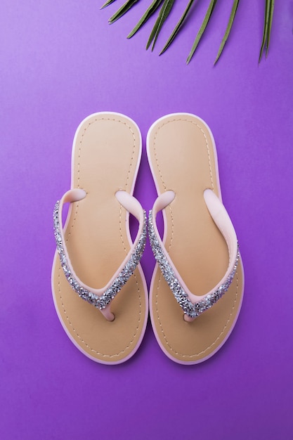 Tongs de plage de belle femme sur le violet ou le violet. concept d'été de plage et concept de vacances, vue de dessus