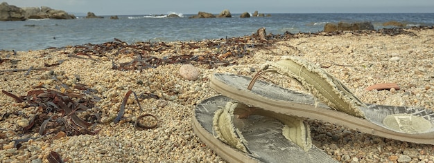 Tongs sur la plage, image de bannière avec espace de copie