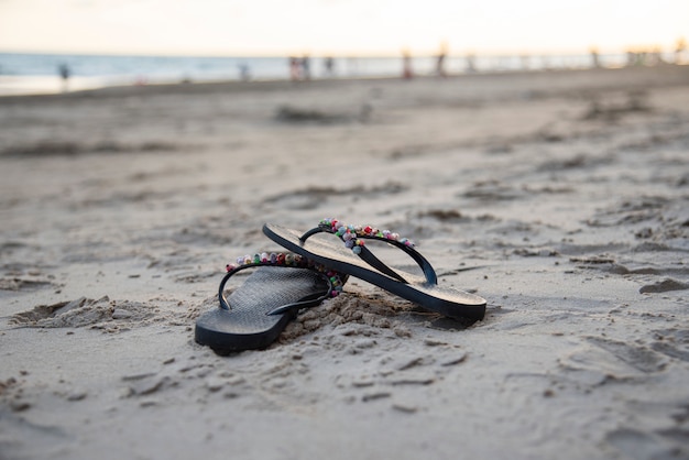 Tongs sur la plage avec plage de sable fin