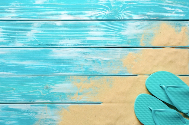 Tongs sur un plancher en bois bleu.