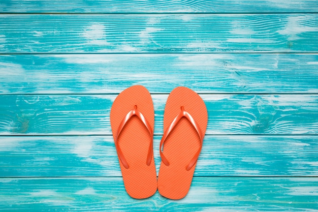 Tongs sur un plancher en bois bleu.