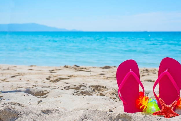 Tongs roses sur le sable