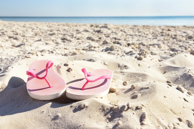 Tongs sur le sable de la plage agrandi