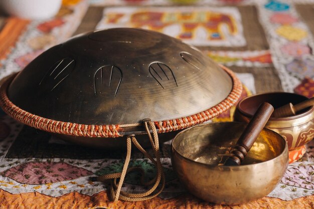 Tongue drum et bols tibétains posés sur le tapis