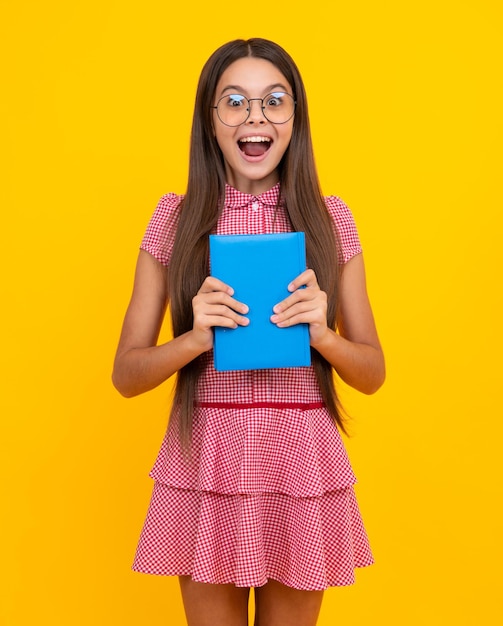 Étonné adolescente adolescente écolière avec des livres fond de studio isolé expression excitée