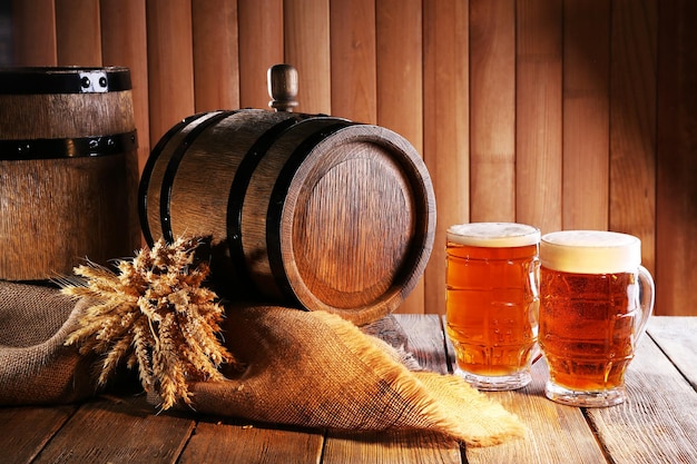 Photo tonneau de bière avec verres à bière sur table sur fond en bois