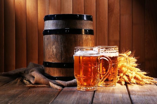 Tonneau de bière avec verres à bière sur table sur fond en bois
