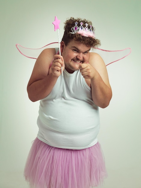 Toothfairy avec une torsion Un homme en surpoids avec une expression coquine portant un costume de fée rose