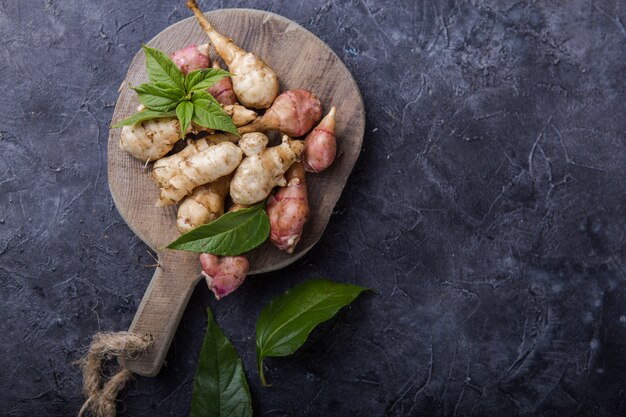 Topinambour (topinambour), également appelé pomme de terre ou tournesol sur une planche à découper.