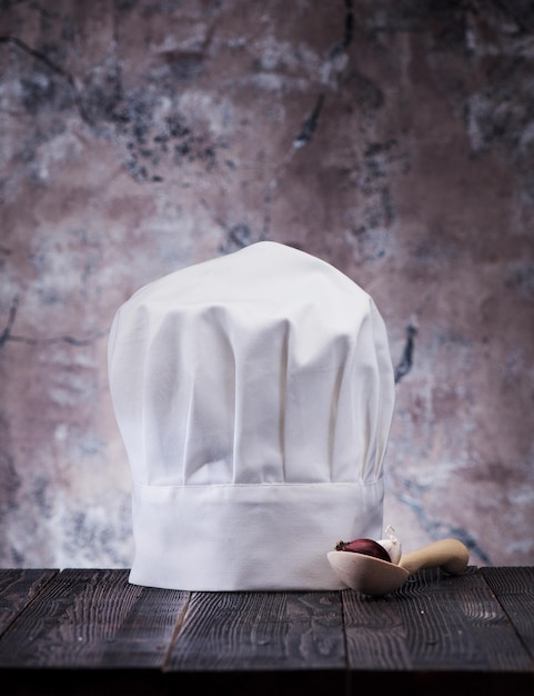 Toque et cuillère en bois sur la table de la cuisine