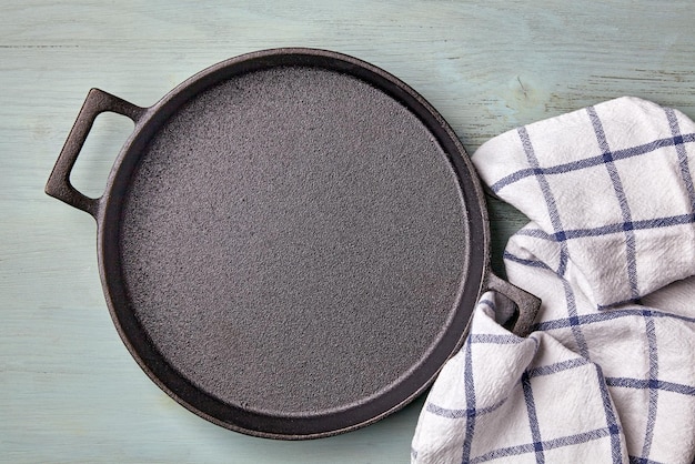 Torchon rond en fonte vide sur une table en bois bleu clair