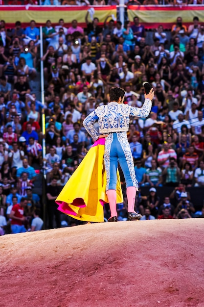 Photo torero faisant des mouvements devant les spectateurs dans l'arène