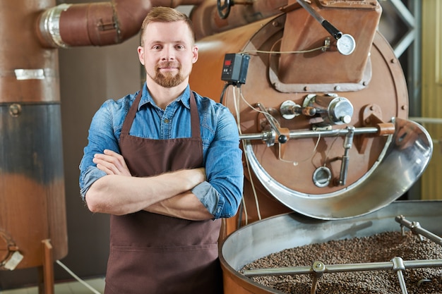 Torréfacteur moderne posant dans une usine de café