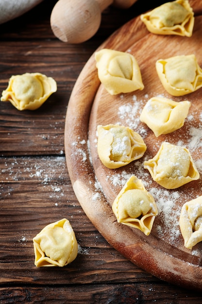 Tortellini traditionnel italien fait maison sur la table en bois