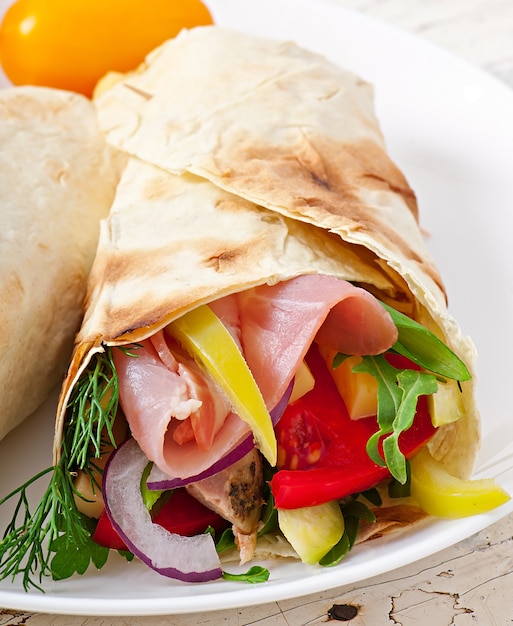 Tortilla fraîche s'enroule avec de la viande et des légumes sur la plaque