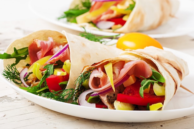 Tortilla fraîche s'enroule avec de la viande et des légumes sur la plaque