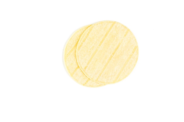 Tortillas de maïs jaune frais sur fond blanc.