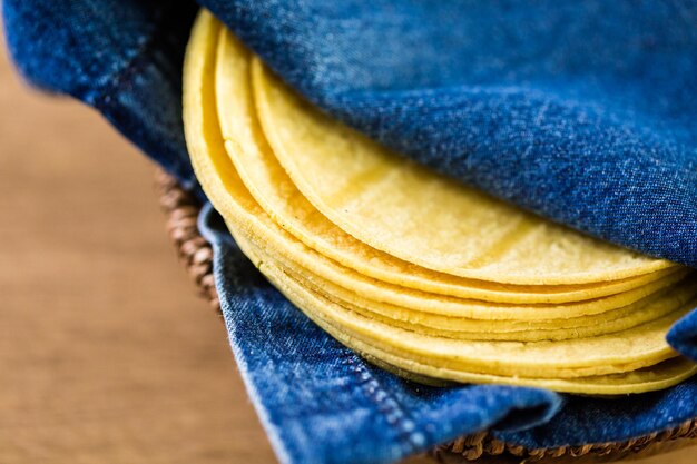 Tortillas de maïs jaune frais sur fond de bois.