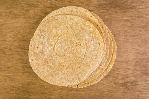 Tortillas multigrains fraîches sur fond de bois.