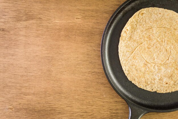 Tortillas multigrains fraîches sur fond de bois.