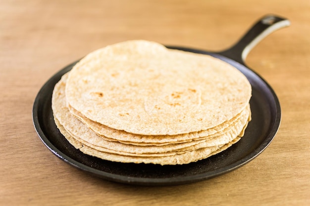 Tortillas multigrains fraîches sur fond de bois.