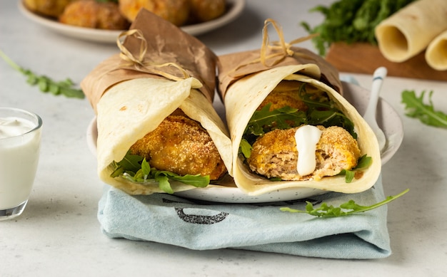 Tortillas Roulées Avec Des Côtelettes De Poulet Ou De Dinde, De La Roquette Et Une Sauce à La Crème Sure.