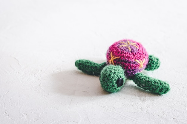 Tortue au crochet à la main sur fond blanc.