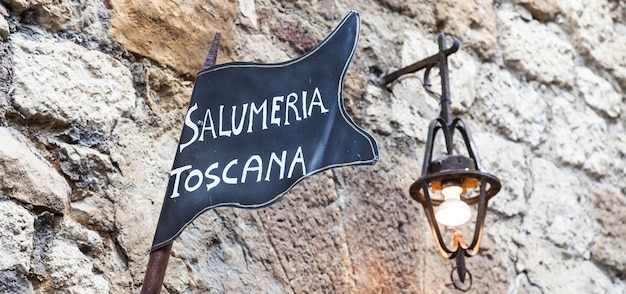 Toscane, Italie. Plaque de rue de boucherie traditionnelle sur un vieux mur