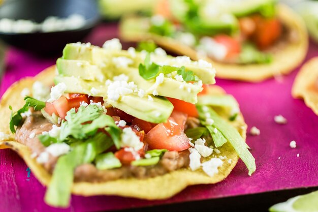 Tostadas mexicaines végétariennes fraîches sur une planche à découper violette.