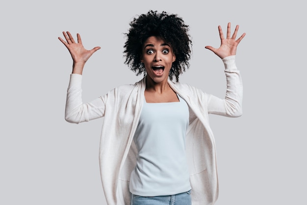 totalement choqué. surpris jeune femme africaine avec la bouche ouverte gesticulant et regardant la caméra