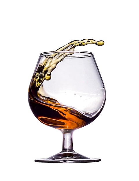 Une touche de brandy dans un verre en verre isolé sur fond blanc