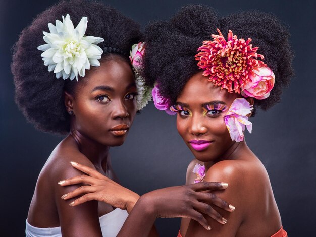 Une touche de nature fait toute la différence Photo recadrée de deux belles femmes posant avec des fleurs dans les cheveux