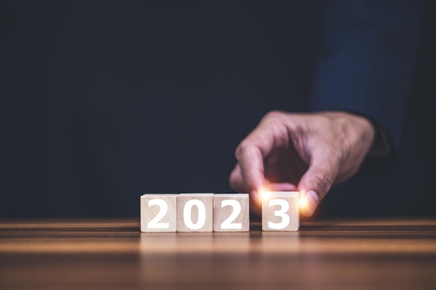 Toucher à la main sur le concept de cube en bois 2023 et l'année du plan 2023