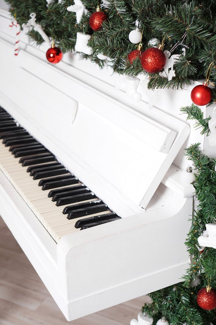 Touches sur piano droit blanc avec décor de Noël avec boules rouges