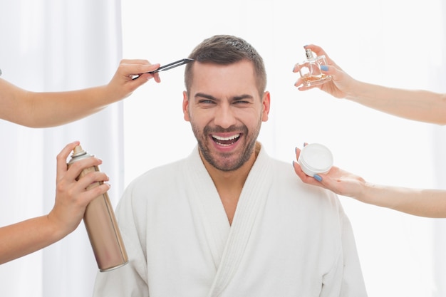 Toujours beau. Bel homme positif souriant tout en profitant des procédures de beauté