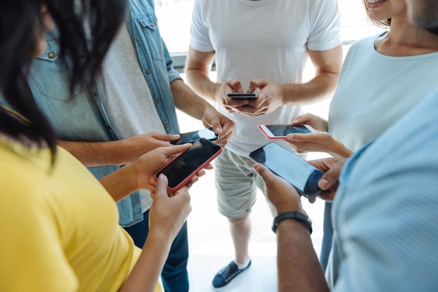 Toujours connecté. Close up de smartphones modernes utilisés par de beaux jeunes intelligents