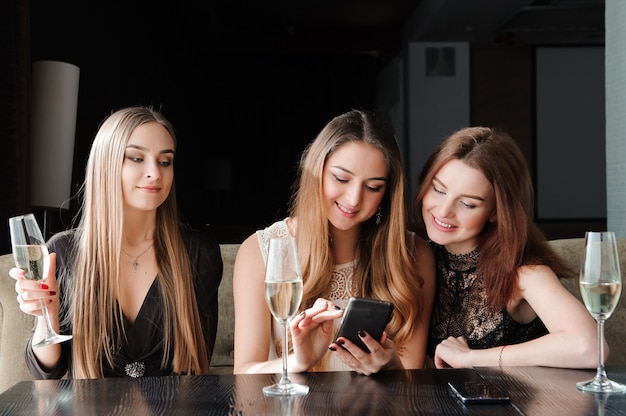 Toujours connecté, dépendance à Internet, jeunes filles dans un café en regardant leurs smartphones, concept de réseau social.