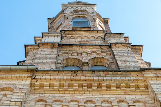 Tour de brique d'une église ou d'une église contre le ciel bleu vieux bâtiment de style gothique