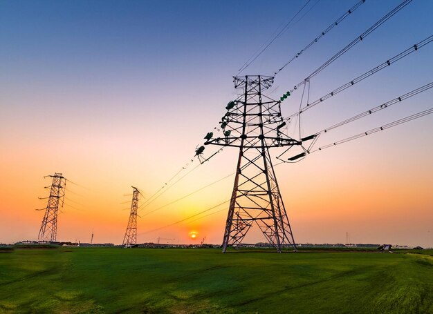 tour d'électricité haute tension ciel coucher du soleil paysage arrière-plan industriel