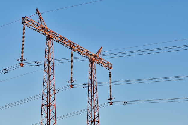 Tour électrique haute tension avec ligne électrique contre le ciel bleu Ligne électrique aérienne avec isolateurs Réseau de transmission et de distribution de production d'électricité Paysage industriel